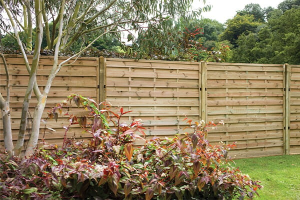 a run of pressure treated decorative fence panels complete with wooden fence posts