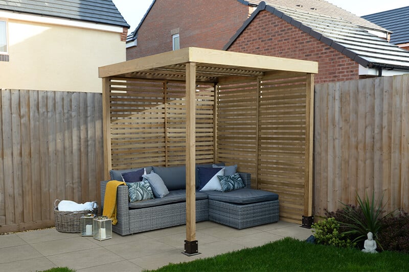 a wooden pergola built against a fence - this can help to add height to a fence