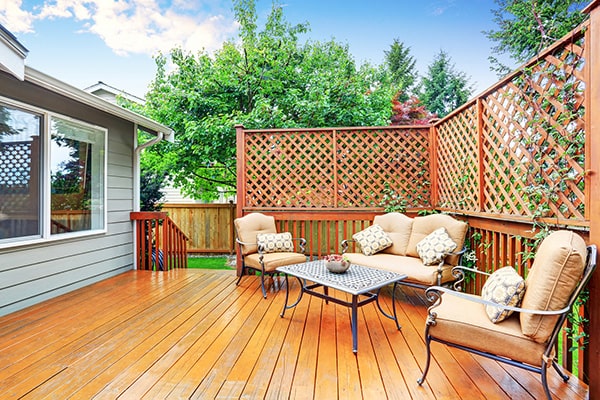 garden furniture on a wood deck, surrounded by trellis