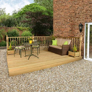 A sofa and garden table and chairs on top of a 3.6mx3.6m wooden garden decking kit with railings.