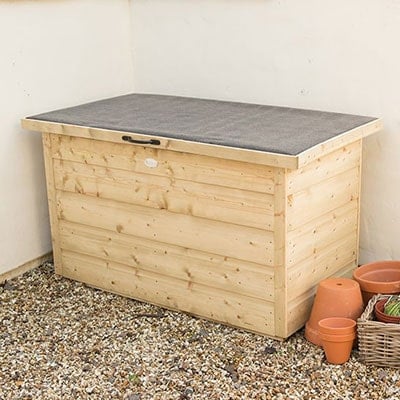 a wooden garden storage chest on a gravel driveway