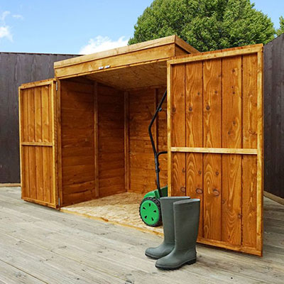 A wooden lawn mower storage shed with its double doors open to reveal a mower