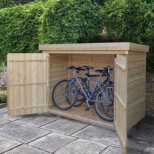 The Forest Large Double Door Pent Wooden Garden Storage Bike Store, situated on a patio and with its doors open to reveal 2 bikes.