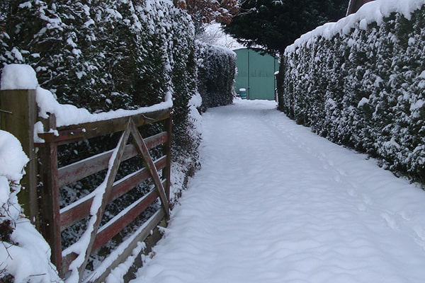 a snow covered driveway with gate 