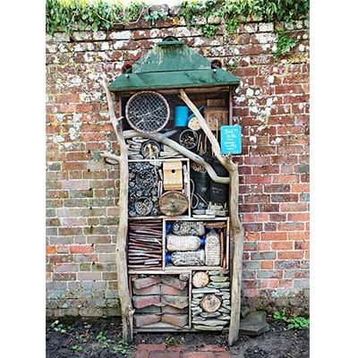 A tall bug hotel with an apex roof